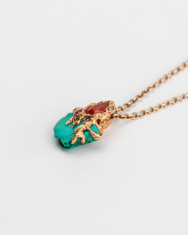angled view of a pendant, highlighting the molten, abstract gold setting that cradles each stone