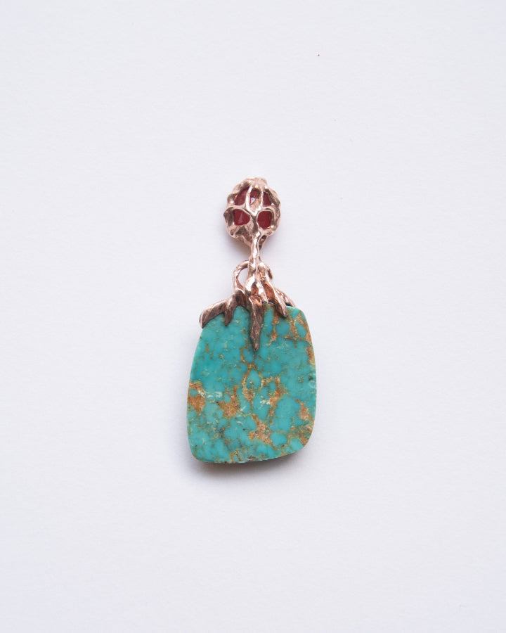 back side of a pendant highlighting the sculpted, abstract design holding a turquoise and orange sapphire