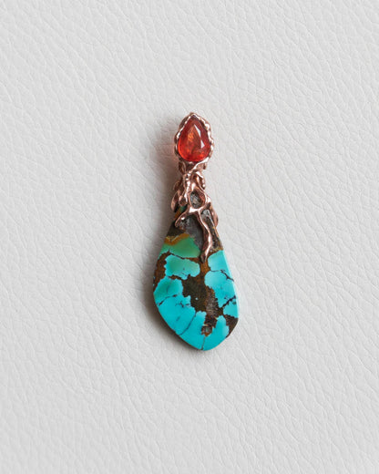 front view of a pendant with free-form gold-plated silver design, featuring an orange sapphire and turquoise slice