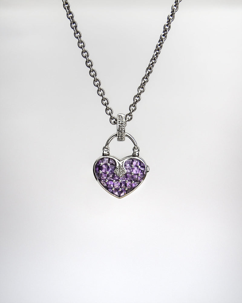 a heart-shaped locket in a white gold setting, featuring amethysts and diamonds, displayed on a small link chain