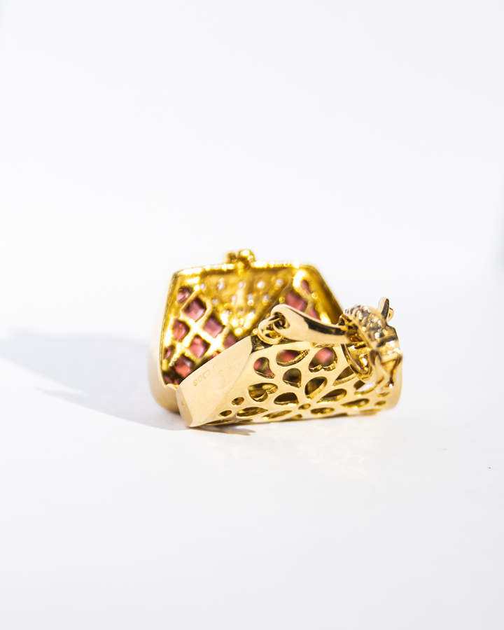 angled view of an 18K yellow gold locket displayed open, highlighting its sentimental and intricate design