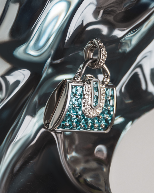 Minaudière Trapeze 18K white gold with blue topaz and diamond locket displayed on resin sculpture