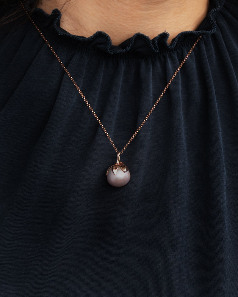 Person wearing Kara 18K rose gold plated silver and freshwater pearl pendant on chain