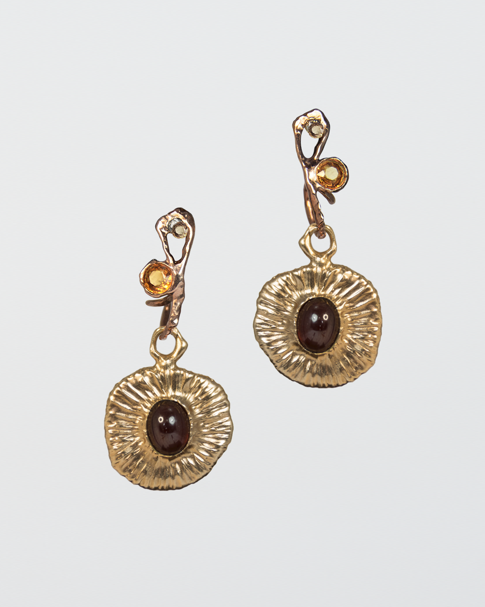 reverse side of detachable drops, featuring garnet oval cabochon in an abstract gold-plated silver setting, hanging from hoop earrings set with citrine and diamond