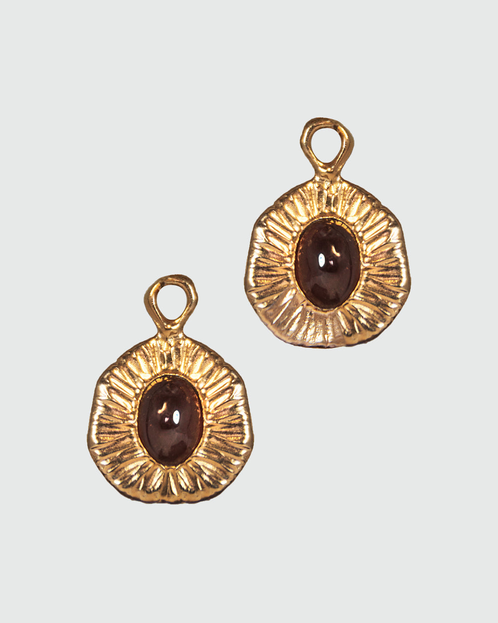 front view of detachable drops featuring garnet oval cabochons in an elegant, free-form silver setting with rose gold plating