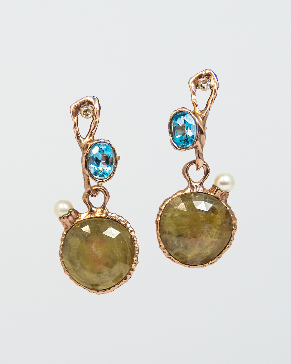 pair of hoop earrings with a free-form setting over blue topaz and diamonds, matched with detachable gold-plated silver drops