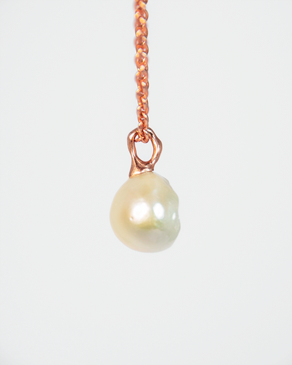 side profile of a pendant with an abstract gold-plated silver setting, highlighting the sculptural design that elegantly displays the pearl