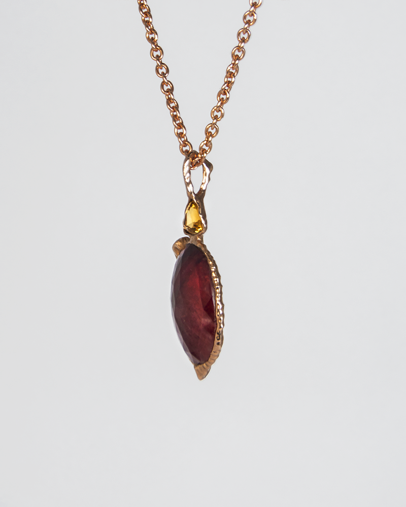angled view of a reversible silver pendant, emphasising the abstract setting that holds each gemstone