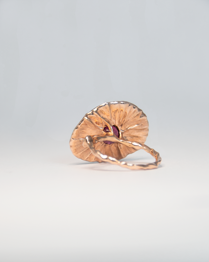 underside of a ring with a rose gold-plated silver design, revealing the hidden ruby cabochon behind the centre stone