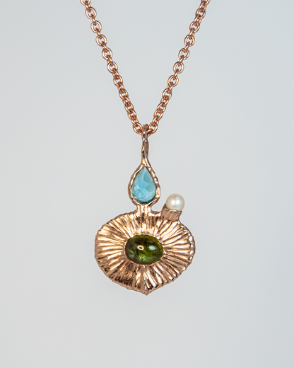 front view of 18K rose gold-plated silver pendant, featuring a green tourmaline oval cabochon with pear-cut blue topaz and small round freshwater pearl