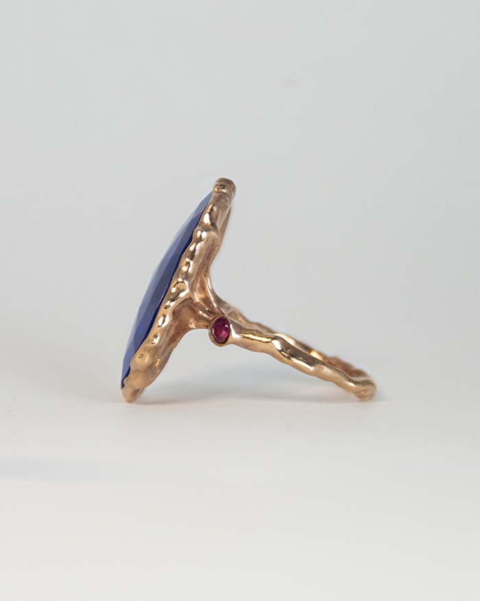 profile of a silver ring, presenting the ruby side stone set in a free-form, abstract band