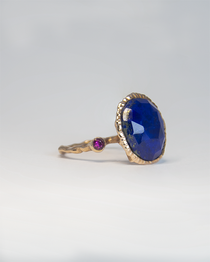 angled view of a rose gold-plated silver ring, emphasising the vibrant lapis lazuli centre stone and pink tourmaline side stone in an organic setting